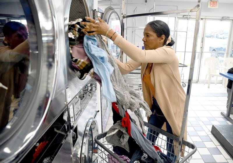 Sofia Roca, an immigrant from Colombia, washes clothes at a laundromat in Aurora, Colorado, on March 29, 2024. (AP Photo/Thomas Peipert)