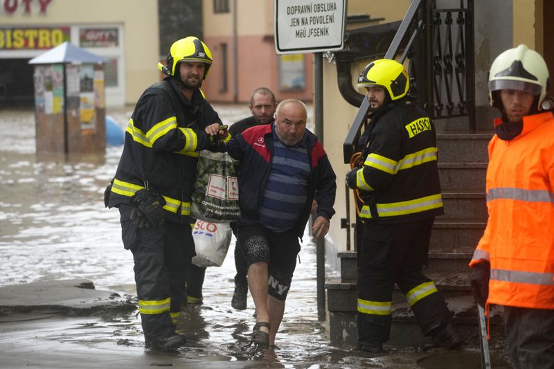 Firemen help a resident during floods in Jesenik, Czech Republic, Sunday, Sept. 15, 2024. (AP Photo/Petr David Josek)