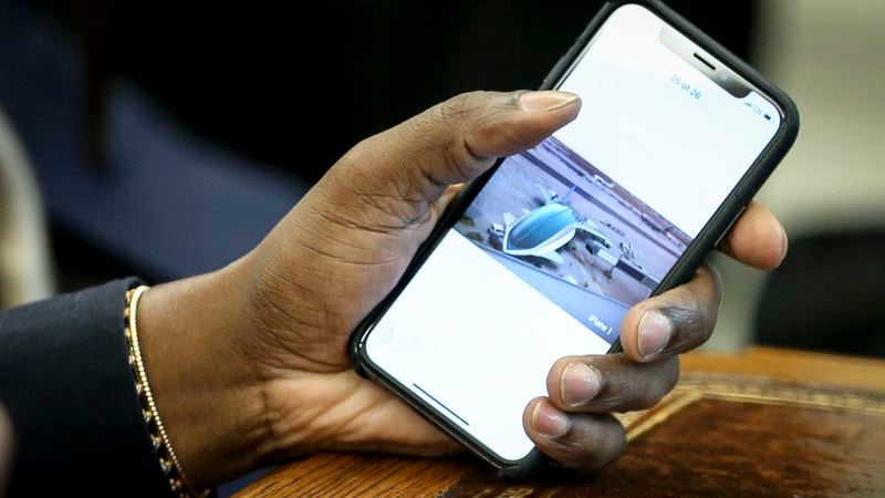 Rapper Kanye West holds his phone with a picture of a plane after he showed it to U.S. President Donald Trump during a meeting in the Oval office of the White House on October 11, 2018 in Washington, DC.