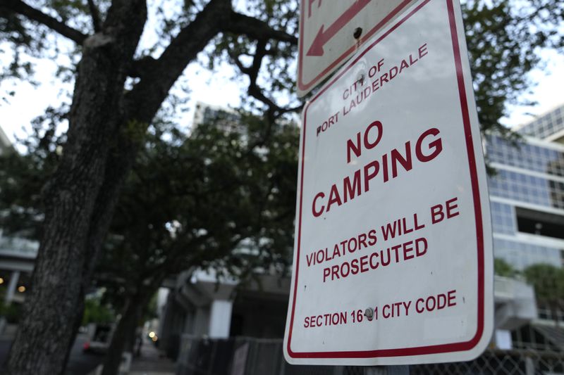 A No Camping sign is posted on the first day of a statute that took effect, making it illegal in Florida to sleep on sidewalks, in parks, on beaches or in other public spaces — one of the country's strictest anti-homelessness laws, Tuesday, Oct. 1, 2024, in Fort Lauderdale, Fla. (AP Photo/Lynne Sladky)