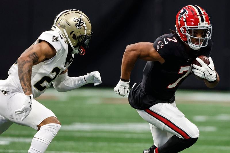 Atlanta Falcons running back Bijan Robinson (7) runs against New Orleans Saints cornerback Marshon Lattimore (23) during the first half of an NFL football game, Sunday, Sept. 29, 2024, in Atlanta. (AP Photo/Butch Dill)