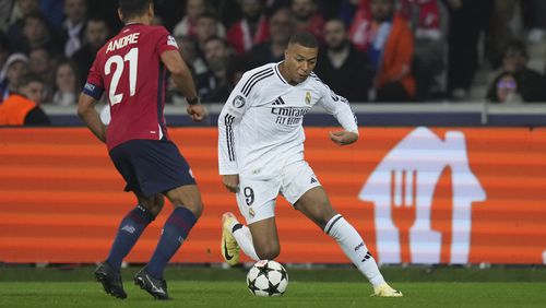 Real Madrid's Kylian Mbappe, right, dribbles the ball past Lille's Benjamin Andre during the Champions League opening phase soccer match between Lille and Real Madrid at the Stade Pierre Mauroy in Villeneuve-d'Ascq, outside Lille, France, Wednesday, Oct. 2, 2024. (AP Photo/Thibault Camus)