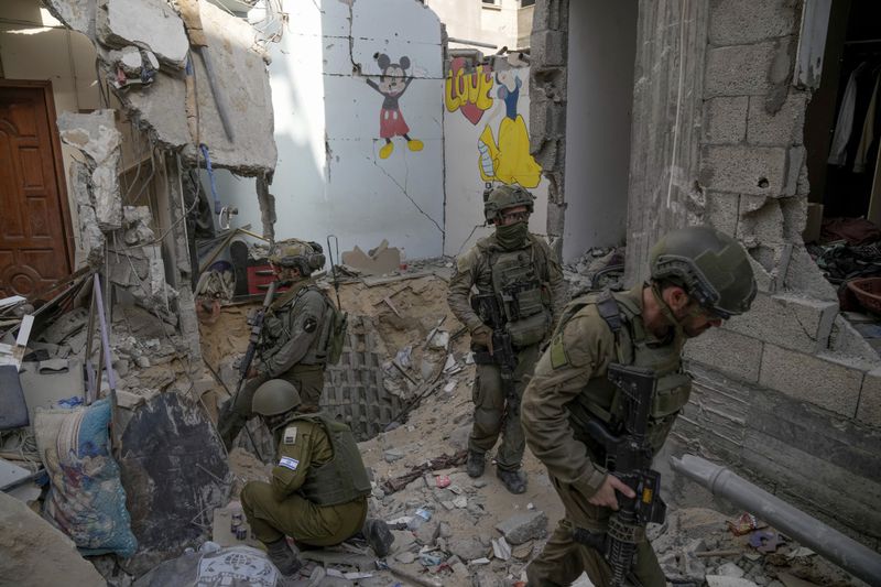 Israeli soldiers stand at the entrance of a tunnel where the military says six Israeli hostages were recently killed by Hamas militants, in the southern Gaza Strip on Friday, Sept. 13, 2024. (AP Photo/Leo Correa)