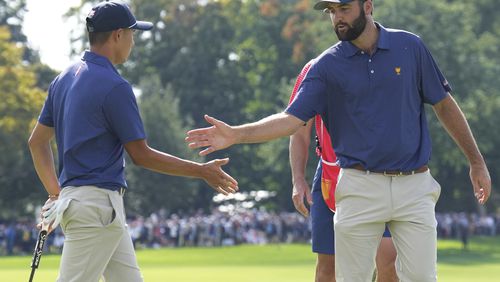 United States team member Scottie Scheffler, right, shakes hands with partner Collin Morikawa after making a putt on the 15th hole during the third round at the Presidents Cup golf tournament at Royal Montreal Golf Club in Montreal Saturday, Sept. 28, 2024. (Nathan Denette/The Canadian Press via AP)