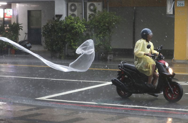 A man rides in the wind and rain generated by Typhoon Krathon in Kaohsiung, southern Taiwan, Thursday, Oct. 3, 2024. (AP Photo/Chiang Ying-ying)