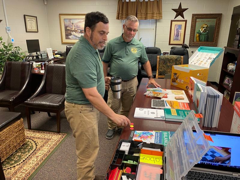 Grayson Elementary School teacher Matt Schoen and Principal Chris Brown look over classroom materials that will be used to help teach reading. Grayson is part of a pilot program in Gwinnett County Public Schools to revamp the district's approach to literacy. (Josh Reyes / Josh.Reyes@ajc.com)