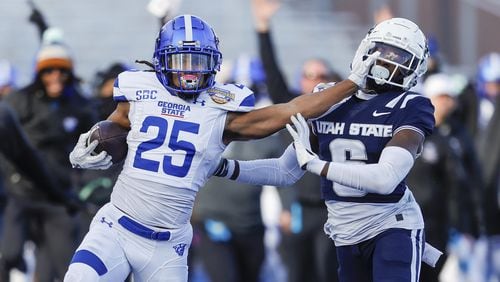 Georgia State running back Freddie Brock (25) stiff arms Utah State safety Ike Larsen (6) in the first half of the Famous Idaho Potato Bowl NCAA college football game, Saturday, Dec. 23, 2023, in Boise, Idaho. (AP Photo/Steve Conner)