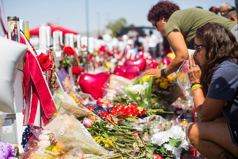 On Aug. 7, 2019, people bring flowers and pray at a makeshift memorial outside the Walmart where 22 people were killed four days earlier, in El Paso, Texas. Since then, the nation’s largest retailer said it would stop selling ammunition for certain short barrel rifles and for all handguns. CELIA TALBOT TOBIN / THE NEW YORK TIMES