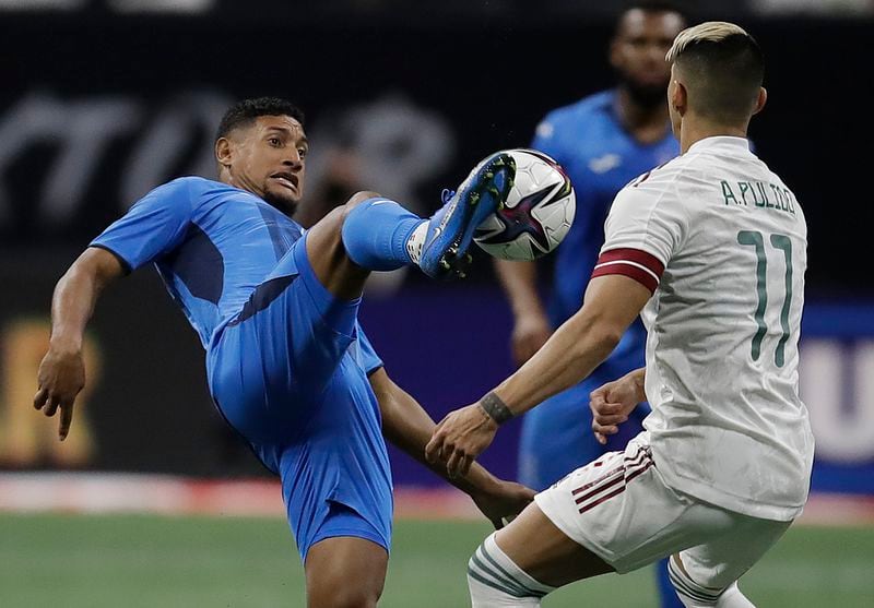 Honduras' Bryan Acosta, left, kicks the ball away from Mexico's Alan Pulido (11) during the second half of an international friendly soccer match Saturday, June 12, 2021, in Atlanta. The match ended in a 0-0 draw. (AP Photo/Ben Margot)