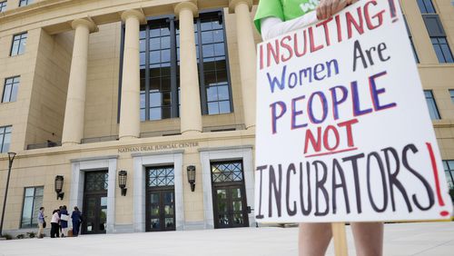 A protester held a sign outside the Nathan Deal Justice Center during the hearing of the challenge to Georgia's abortion law at the Georgia Supreme Court on Tuesday, March 28, 2023.
 Miguel Martinez / miguel.martinezjimenez@ajc.com