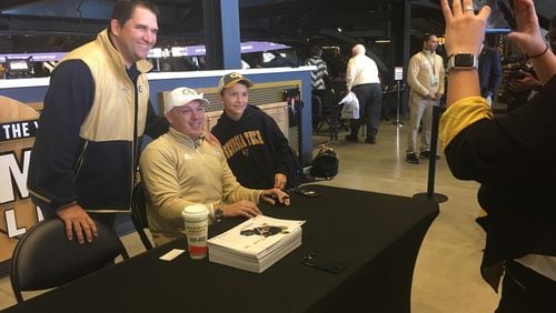 New Georgia Tech coach Geoff Collins takes a photo with fans Saturday at McCamish Pavilion prior to the basketball team's ACC opener against Wake Forest. (AJC photo by Ken Sugiura)