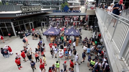 Atlanta Braves fans look over their replica World Series ring as they enter the right field gate before the Atlanta Braves Braves host the New York Mets at Truist Park Monday, July 11, 2022, in Atlanta. (Jason Getz / Jason.Getz@ajc.com)