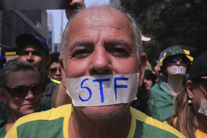 A demonstrator, his mouth covered with tape marked with the Brazilian Supreme Court acronym, takes part in a demonstration calling for the impeachment of Supreme Court Minister Alexandre de Moraes, who recently imposed a nationwide block on Elon Musk’s social media platform X, in Sao Paulo, Saturday, Sept. 7, 2024. (AP Photo/Ettore Chiereguini)