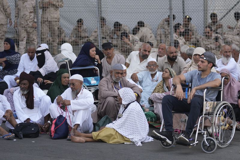 Muslim pilgrims rest after casting stones at pillars in the symbolic stoning of the devil, the last rite of the annual hajj, in Mina, near the holy city of Mecca, Saudi Arabia, Tuesday, June 18, 2024. Muslim pilgrims were wrapping up the Hajj pilgrimage in the deadly summer heat on Tuesday with the third day of the symbolic stoning of the devil, and the farewell circling around Kaaba in Mecca's Grand Mosque. (AP Photo/Rafiq Maqbool)