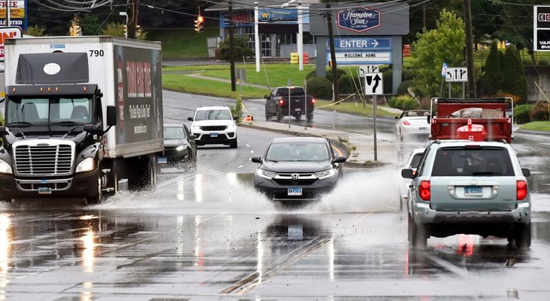 Vehicles pass through water on Newtown Rd. in Danbury, Conn., Monday, Aug. 19, 2024. (H John Voorhees III/Hearst Connecticut Media)