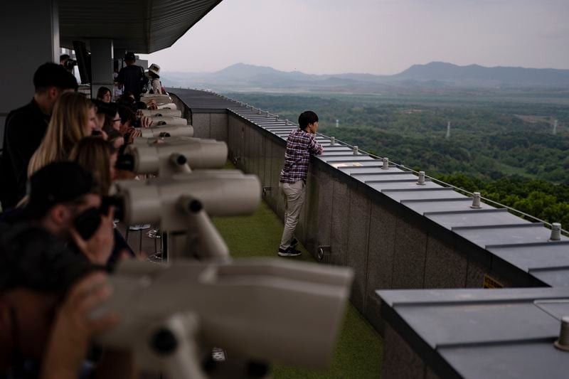 Tourists use binoculars to view North Korea from the Dora Observation Post in the Demilitarized Zone (DMZ) in Paju, South Korea, Saturday, May 25, 2024. (AP Photo/Jae C. Hong)