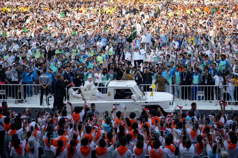 Pope Francis waves to greet the crowd as he arrives at Madya Stadium in Jakarta, Indonesia, Thursday, Sept. 5, 2024. (AP Photo/Tatan Syuflana)