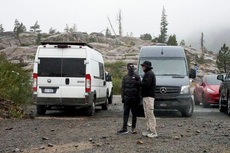 Snow comes down on two motorists Saturday, Aug. 24, 2024, in Donner Summit, Calif. (AP Photo/Brooke Hess-Homeier)