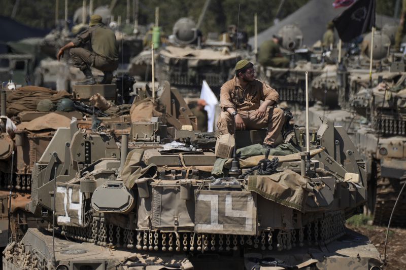 Israeli soldiers work on tanks in northern Israel on Friday, Sept. 27, 2024. (AP Photo/Baz Ratner)