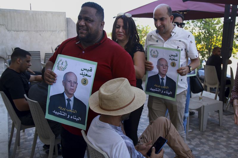 Supporters of Tunisian President and candidate for re-election Kais Saied meet with residents of a neighbourhood during a campaign tour, in Ariana, Tunisia, Thursday, Sept. 26, 2024. (AP Photo/Anis Mili)