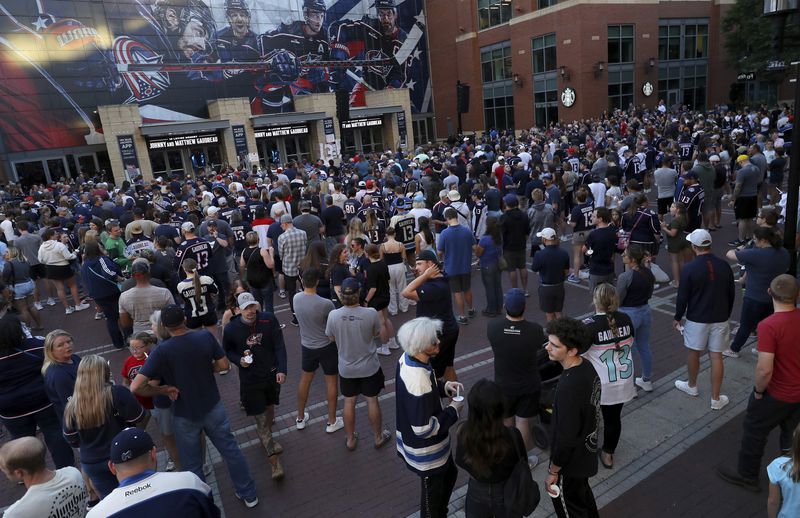 Fans gather for a candlelight vigil to honor Columbus Blue Jackets hockey player Johnny Gaudreau, Thursday, Sept. 4, 2024, outside of Nationwide Arena in Columbus, Ohio. Gaudreau and his brother Matthew were killed by a motor vehicle last week while riding bicycles. (AP Photo/Joe Maiorana)