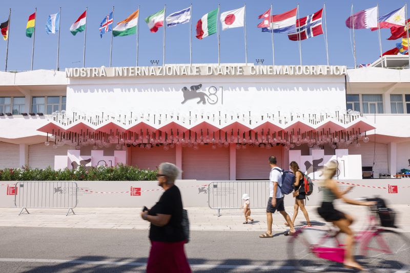 Festival goers pass the red carpet of the 81st edition of the Venice Film Festival in Venice, Italy, on Tuesday, Aug. 27, 2024. The festival runs from Aug. 27 until Sept. 8. (Photo by Vianney Le Caer/Invision/AP)