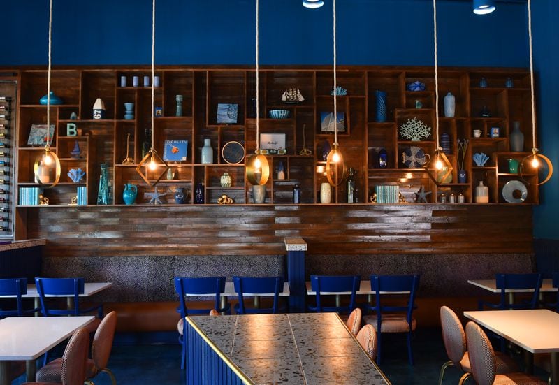 The large display shelving at Just Brunch features lots of blue items including many of owner and chef Keith Kash's mother's personal items, including albums, eight track tapes and pottery.  (CHRIS HUNT FOR THE ATLANTA JOURNAL-CONSTITUTION)