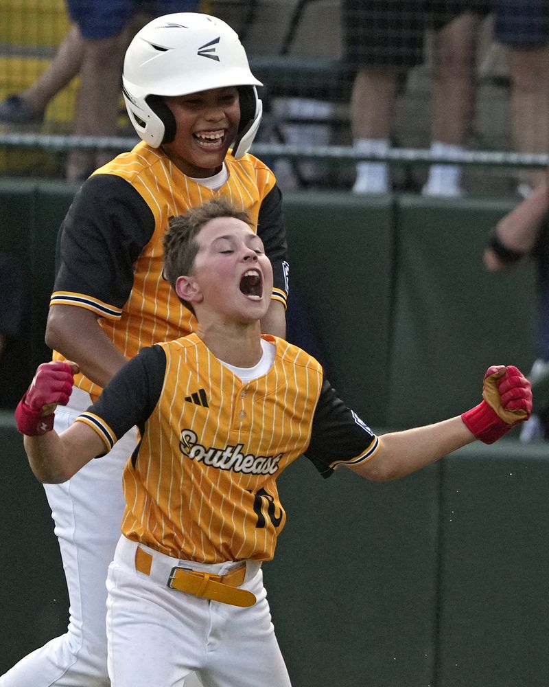 Lake Mary, Fla.'s Hunter Alexander, front, celebrates with teammates after laying down a walk-off bunt in the eighth inning of the Little League World Series Championship game against Taiwan in South Williamsport, Pa., Sunday, Aug. 25, 2024. (AP Photo/Gene J. Puskar)