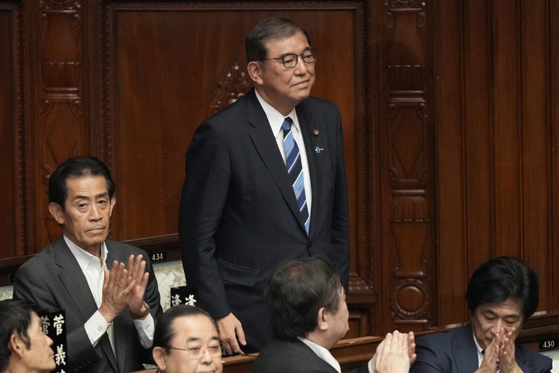 Shigeru Ishiba, center, the head of Japan's ruling party, the Liberal Democratic Party, is applauded after being elected as Japan's prime minister at the extraordinary session of parliament's lower house Tuesday, Oct. 1, 2024, in Tokyo. (AP Photo/Eugene Hoshiko)