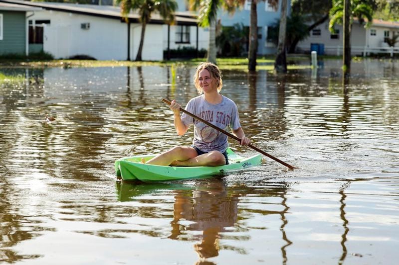 Halle Brooks kayaks down a street flooded by Hurricane Helene in the Shore Acres neighborhood Friday, Sept. 27, 2024, in St. Petersburg, Fla. (AP Photo/Mike Carlson)