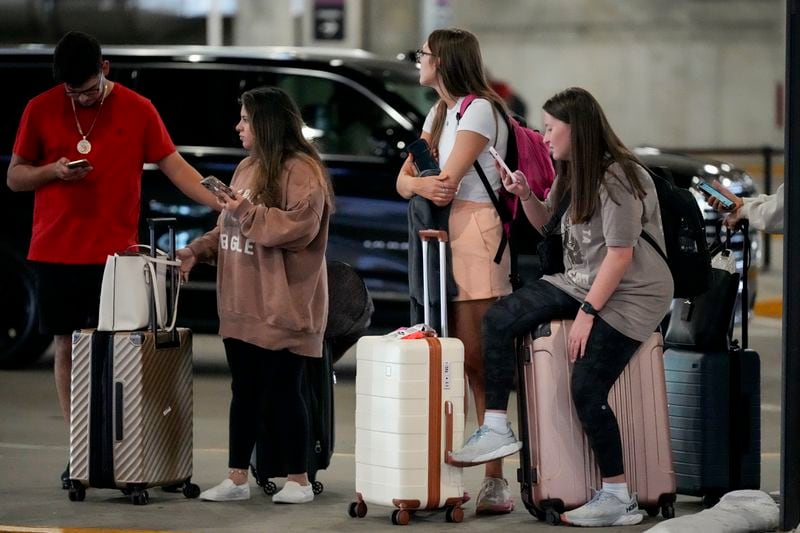 Travelers wait for their ride share vehicles at the Nashville International Airport, Friday, Aug. 30, 2024, in Nashville, Tenn. (AP Photo/George Walker IV)