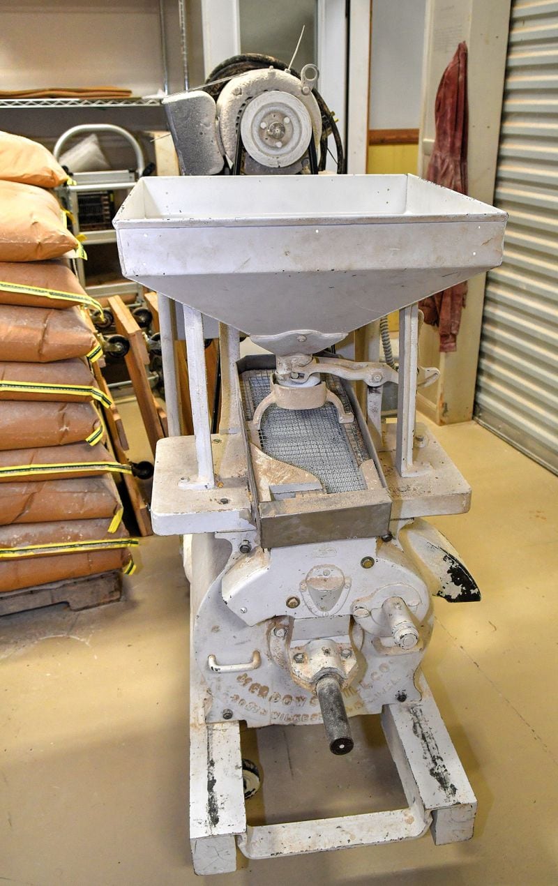 A milling machine, the next step after cleaning, uses stones to grind the grains into a powdery consistency before sifting, which makes the substance's consistency even smaller. DaySpring Farms is an organic certified farm that grows, harvests and mills grains on-site. (Chris Hunt for The Atlanta Journal-Constitution)