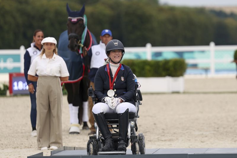 Roxanne Trunnell of the U.S. celebrates her silver medal in the equestrian grade I individual event at the Palace of Versailles, at the 2024 Paralympics, Tuesday, Sept. 3, 2024. (AP Photo/Kileigh Kane)