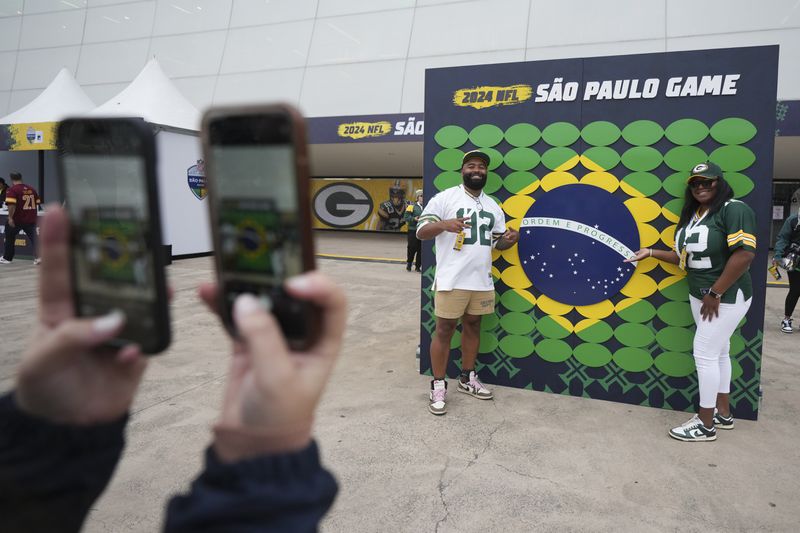 Fans pose before an NFL football game between the Philadelphia Eagles and the Green Bay Packers on Friday, Sept. 6, 2024, at the Neo Quimica Arena in Sao Paulo. (AP Photo/Fernando Llano)