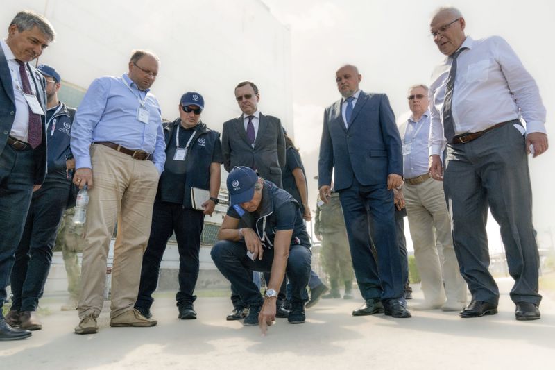 In this photo released by Rosatom State Atomic Energy Corporation, International Atomic Energy Agency chief Rafael Grossi, center, looks at a damage after shelling by Ukraine forces while inspecting the Kursk Nuclear Power Plant (KNPP) outside the town of Kurchatov, in the Kursk region, Russia, Tuesday, Aug. 27, 2024. (Rosatom State Atomic Energy Corporation via AP)