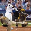 Los Angeles Dodgers' Shohei Ohtani, middle left, connects for a three-run home run off San Diego Padres starting pitcher Dylan Cease (84) during the second inning in Game 1 of baseball's NL Division Series, Saturday, Oct. 5, 2024, in Los Angeles. (AP Photo/Mark J. Terrill)