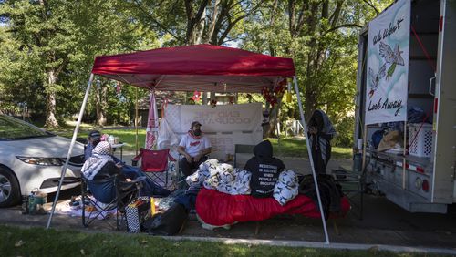 Protesters, including Mike Madanat, center in the white t-shirt, gather near Ohio Democratic Rep. Greg Landsman's Cincinnati residence, Monday, Oct. 7, 2024. (AP Photo/Carolyn Kaster)