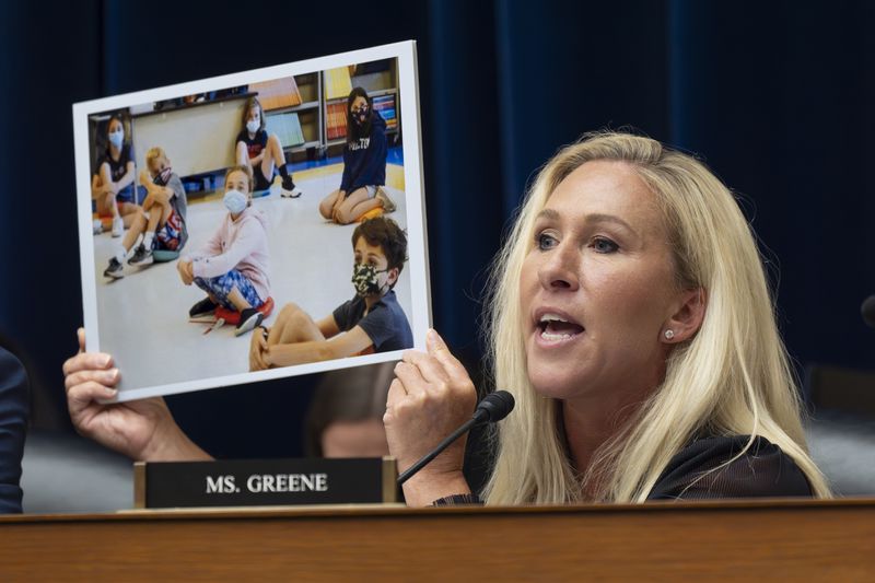 Rep. Marjorie Taylor Greene, R-Ga., holds up a photo as she condemns Dr. Anthony Fauci, the former Director of the National Institute of Allergy and Infectious Diseases, during his testimony before the House Oversight and Accountability Committee Select Subcommittee on the Coronavirus Pandemic, at the Capitol in Washington, Monday, June 3, 2024. (AP Photo/J. Scott Applewhite)