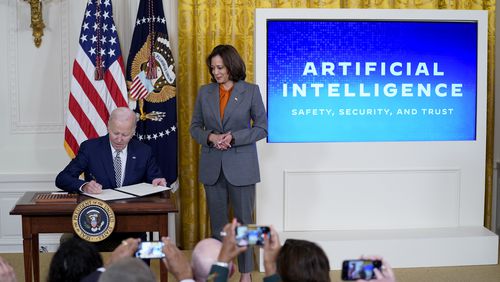 FILE - President Joe Biden signs an executive on artificial intelligence in the East Room of the White House, Oct. 30, 2023, in Washington. Vice President Kamala Harris looks on at right. (AP Photo/Evan Vucci, File)