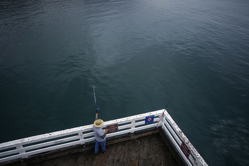 A person fishes on the pier Thursday, Sept. 12, 2024, Malibu, Calif., following a 4.7 magnitude earthquake in the area. (AP Photo/Eric Thayer)