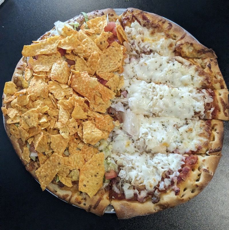 A pizza from Generations Pizza featuring half taco (left) and half German toppings of sausage, Canadian bacon, sauerkraut and onions. Courtesy of Paula Pontes
