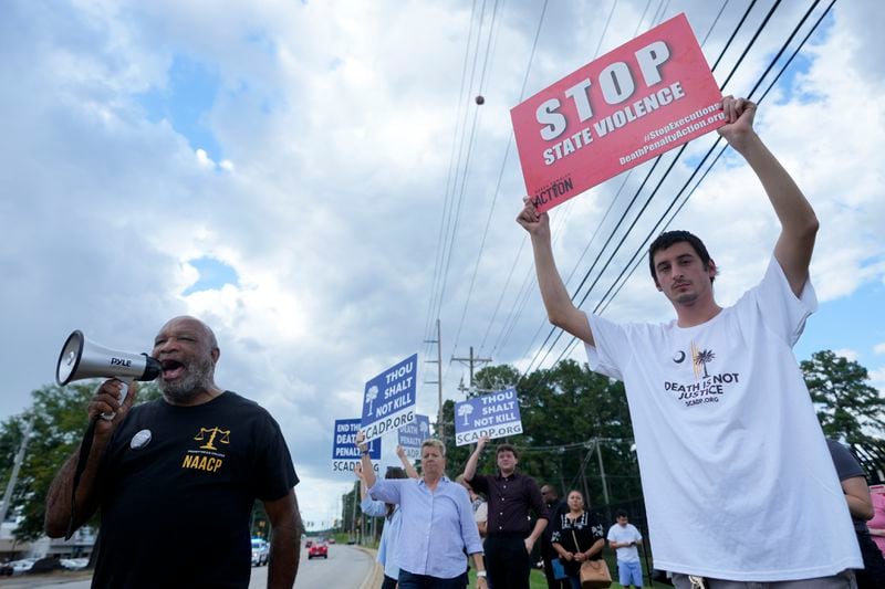 Jesse Motte, right, protests the planned execution of Freddie Eugene Owens, 46, on Friday, Sept. 20, 2024, in Columbia, S.C. Owens is set to be the first person to be executed in South Carolina in 13 years. (AP Photo/Chris Carlson)