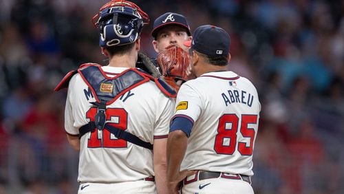 Braves catcher Sean Murphy (12), pitcher Aaron Bummer (center) and  bullpen coach Erick Abreu (85) confer on the mound during the eighth inning against the Rockies at Truist Park in Atlanta on Thursday, Sept. 5, 2024. (Arvin Temkar / AJC)