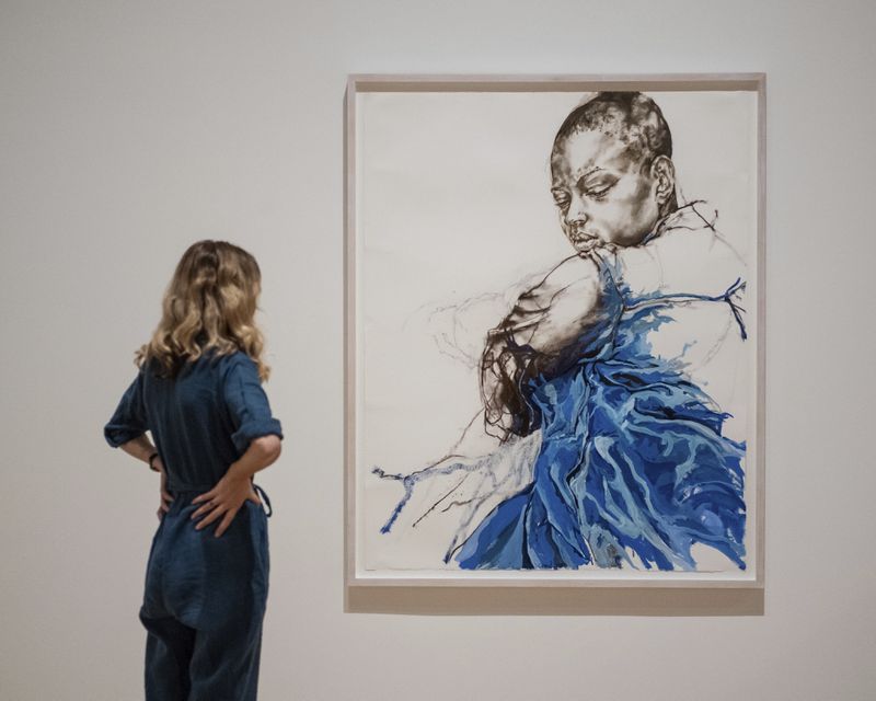 A woman looks at an artwork by Claudette Johnson during the Turner Prize 2024 press preview at Tate Britain in London, part of the 40th anniversary exhibition featuring four shortlisted artists, Tuesday, Sept. 24, 2024. (AP Photo/Thomas Krych)