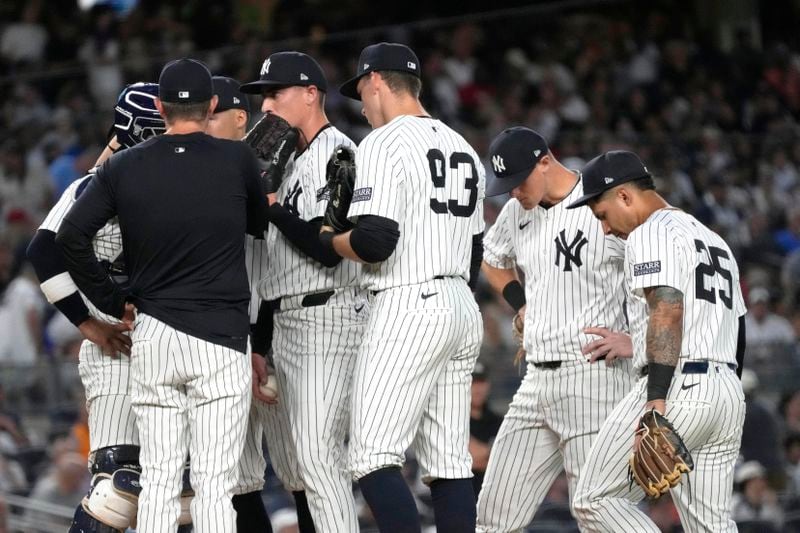 New York Yankees players meet at the pitcher's mound after Baltimore Orioles' Ryan Mountcastle walks to first base during the fifth inning of a baseball game, Wednesday, June 19, 2024, in New York. (AP Photo/Pamela Smith)
