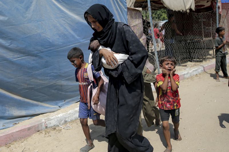 Palestinians evacuate from a site hit by an Israeli bombardment on Khan Younis, southern Gaza Strip, Saturday, July 13, 2024. Israel said it targeted Hamas' shadowy military commander in a massive strike Saturday in the crowded southern Gaza Strip that killed at least 71 people, according to local health officials. Hamas immediately rejected the claim that Mohammed Deif was targeted. (AP Photo/Jehad Alshrafi)