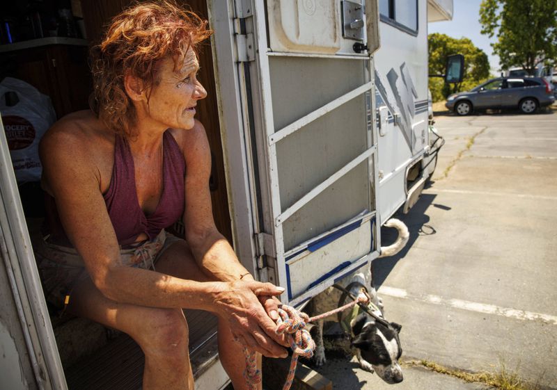 Evacuee Misti Morrow Mosley sits on the steps of an RV at an evacuation shelter as the Thompson Fire burns, Wednesday, July 3, 2024, in Oroville, Calif. (AP Photo/Ethan Swope)