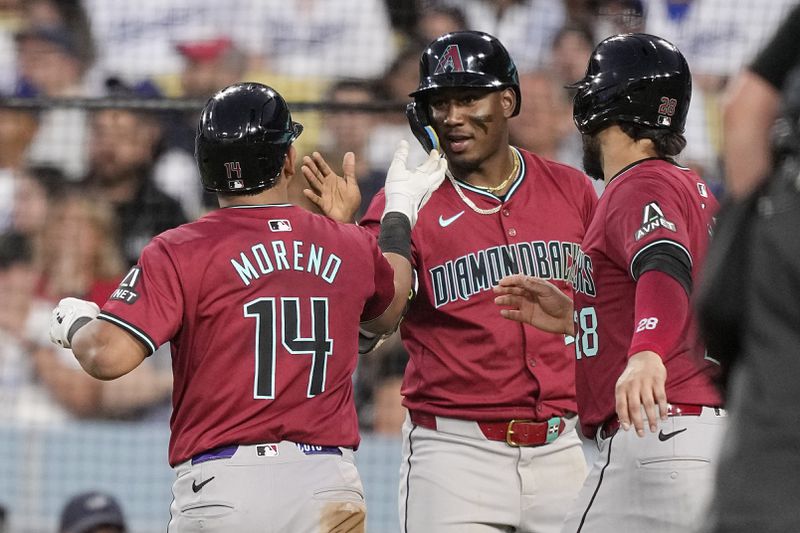 Arizona Diamondbacks' Gabriel Moreno, left, is congratulated by Geraldo Perdomo, center, and Eugenio Suarez after hitting a two-run home run during the third inning of a baseball game against the Los Angeles Dodgers Wednesday, July 3, 2024, in Los Angeles. (AP Photo/Mark J. Terrill)
