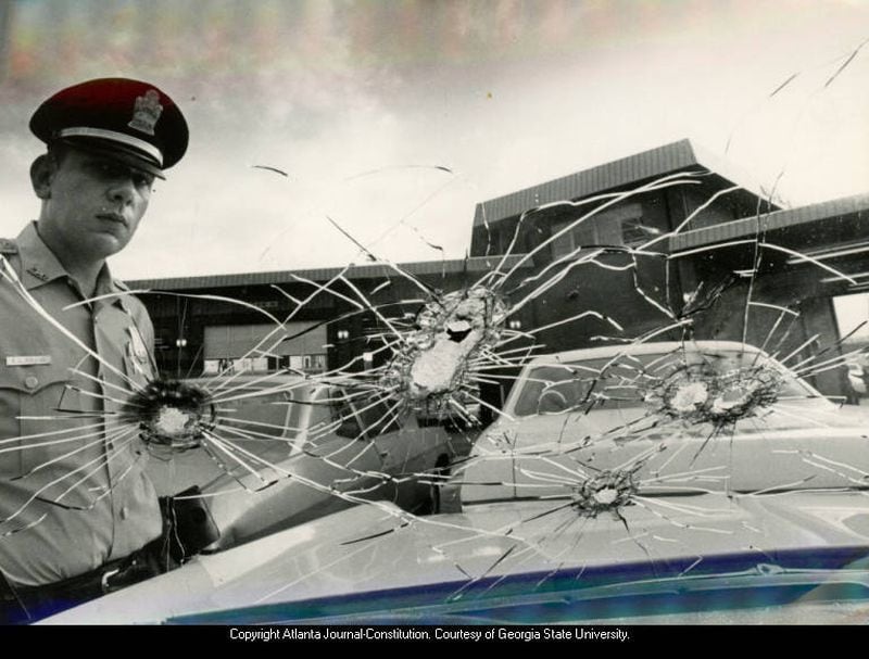 1971 -- Atlanta Police patrolman F.L. Gollus examines six bullet holes in the windshield of a police car. DWIGHT ROSS JR. / AJC FILE