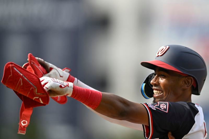 Washington Nationals' Darren Baker celebrates his first major League hit at first base during the ninth inning of a baseball game against the Chicago Cubs, Sunday, Sept. 1, 2024, in Washington. (AP Photo/John McDonnell)